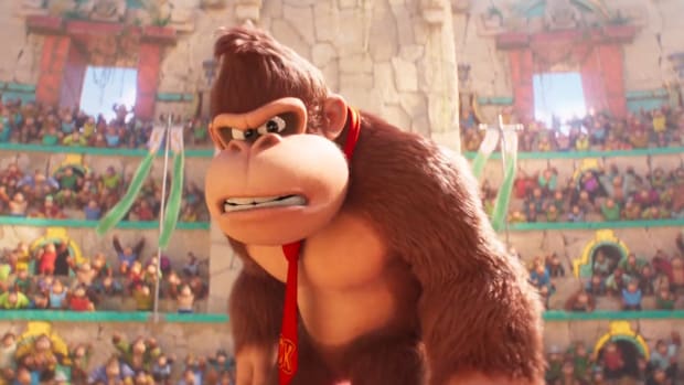 Illumination reveals Cat Mario in Mario movie, but fans love DK more: An animated gorilla with pointy hair and a red tie is standing in the middle of a crowded arena. He wears an expression of anger and confusion