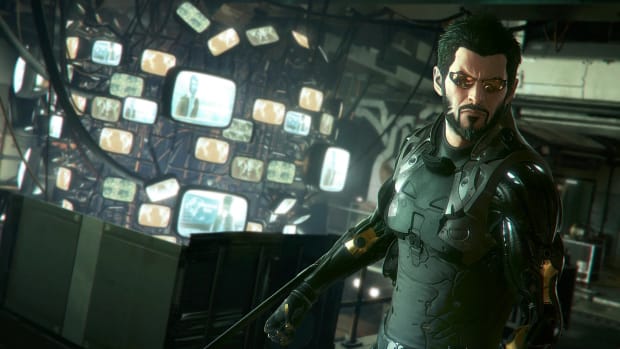 Adam Jensen stares at the camera, backed by a wall full of monitors, in Deus Ex: Mankind Divided.