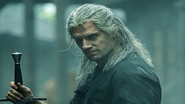 Henry Cavill as Geralt of Rivia, with his right hand resting on the hilt of a sword