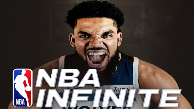 Karl-Anthony Towns of the Minnesota Timberwolves, clenching his hands together and shouting behind the NBA Infinite Logo