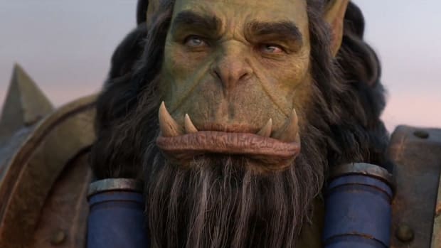 A giant orc with long hair in braids is staring pensively in the distance