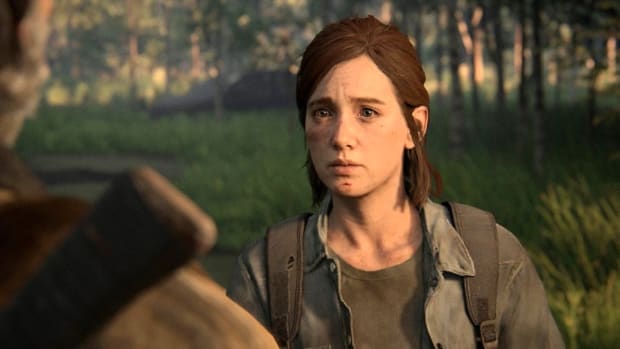 An animated young woman with short brown hair is standing in the middle of a woodland clearing with a look of hurt and surprise on her face.