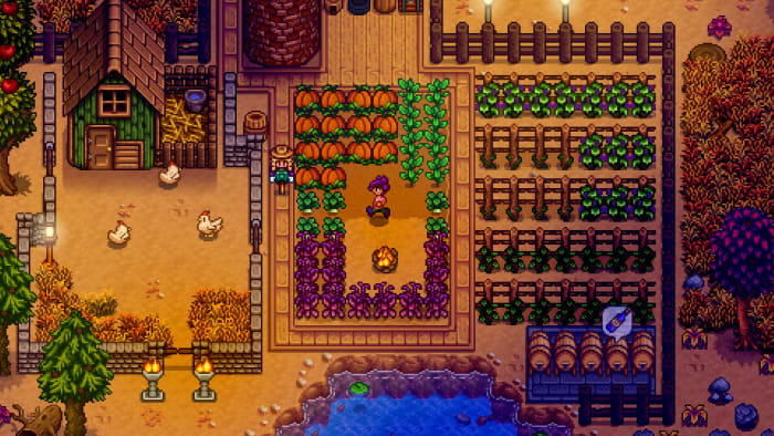 The Stardew Valley 1.5 mobile update is almost ready: A pixel person with purple hair is standing in a dirt field, surrounded by pumpkins, grapevines, and other crops.  A green chicken house is nearby, illuminated by torchlight