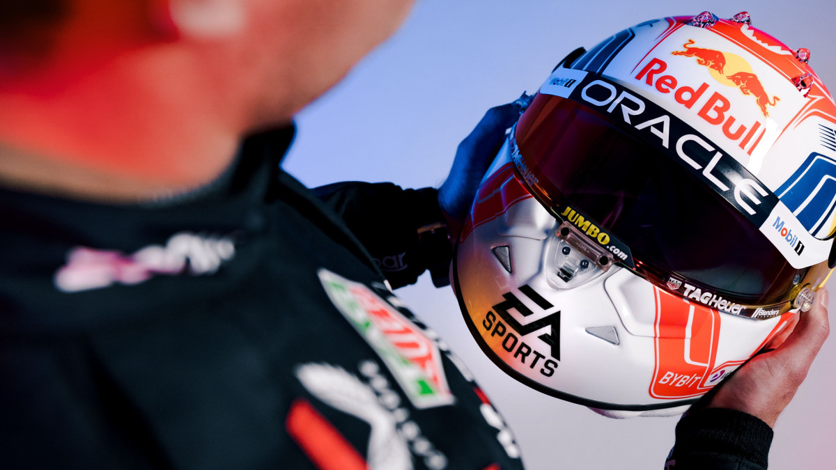 Max Verstappen holding an EA Sports-branded helmet.