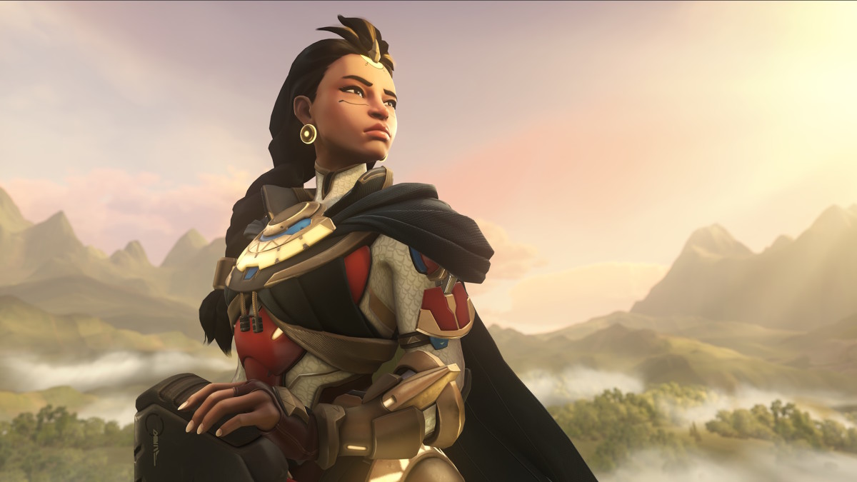 A young woman in golden armor with an elaborate hair braid is standing on a mountaintop, observing the sunrise
