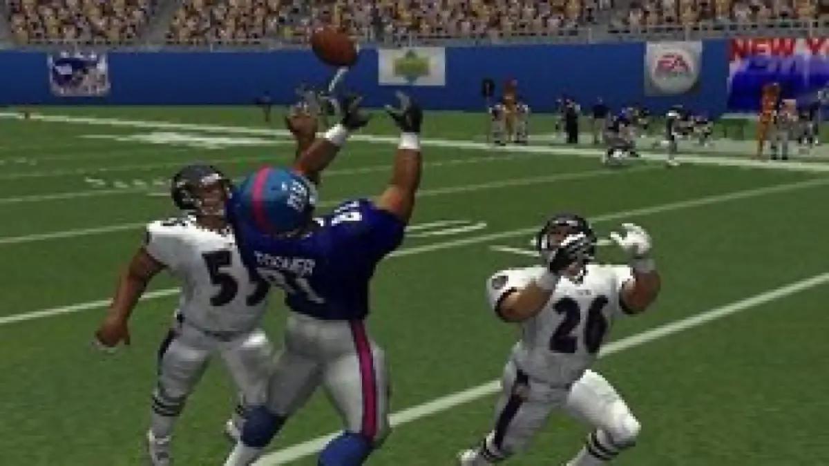 Three polygonal players jostle to catch the ball in Madden 2002.