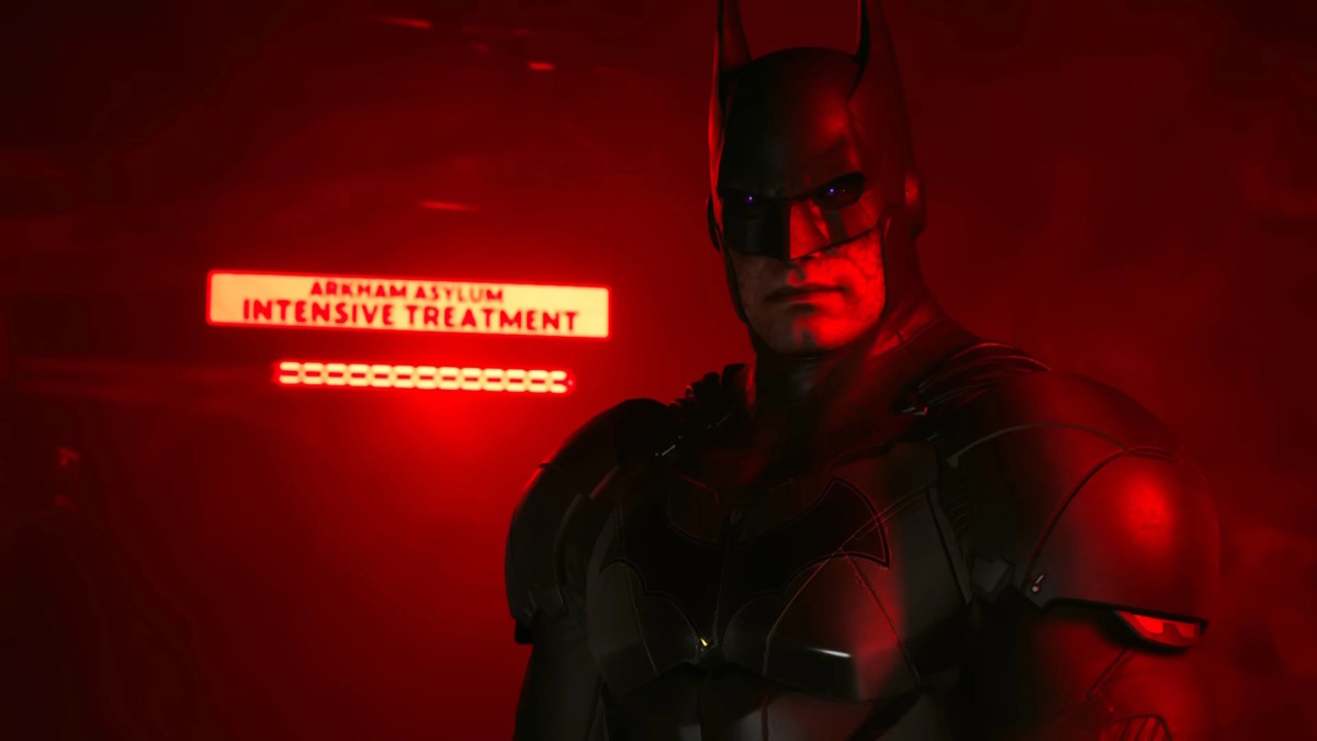 Arkham Batman from Kill the Justice League stands in front of Arkham Asylum, bathed in eerie red light