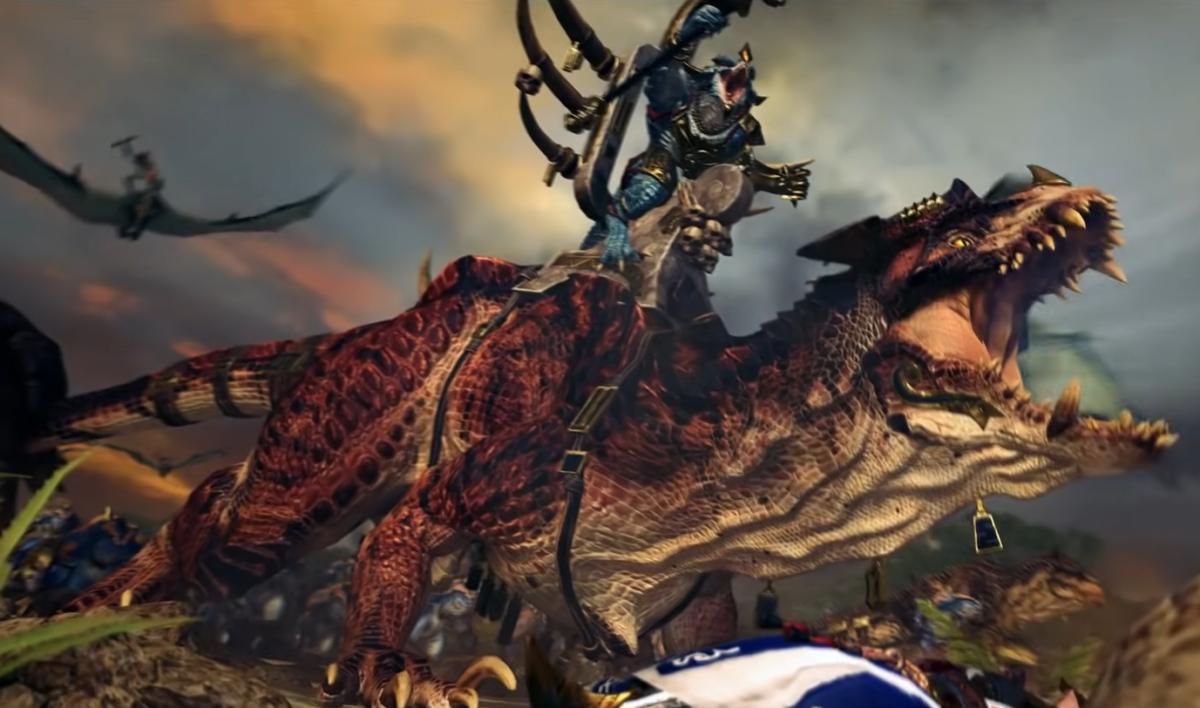 Total War: Warhammer 2 trailer screenshot showing a Lizardman riding a giant carnosaur.