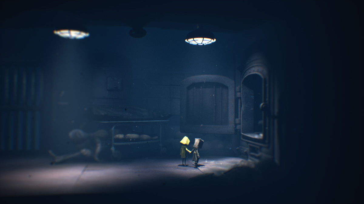 Little Nightmares 2 screenshot showing two little figures in a dark room.