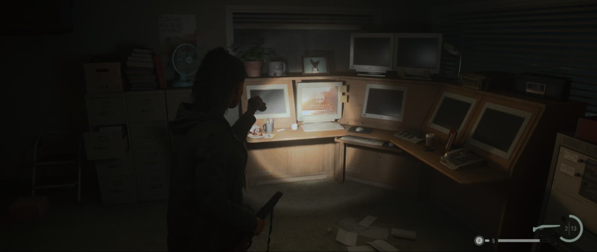 Saga in Alan Wake 2 pointing her torch at a computer.
