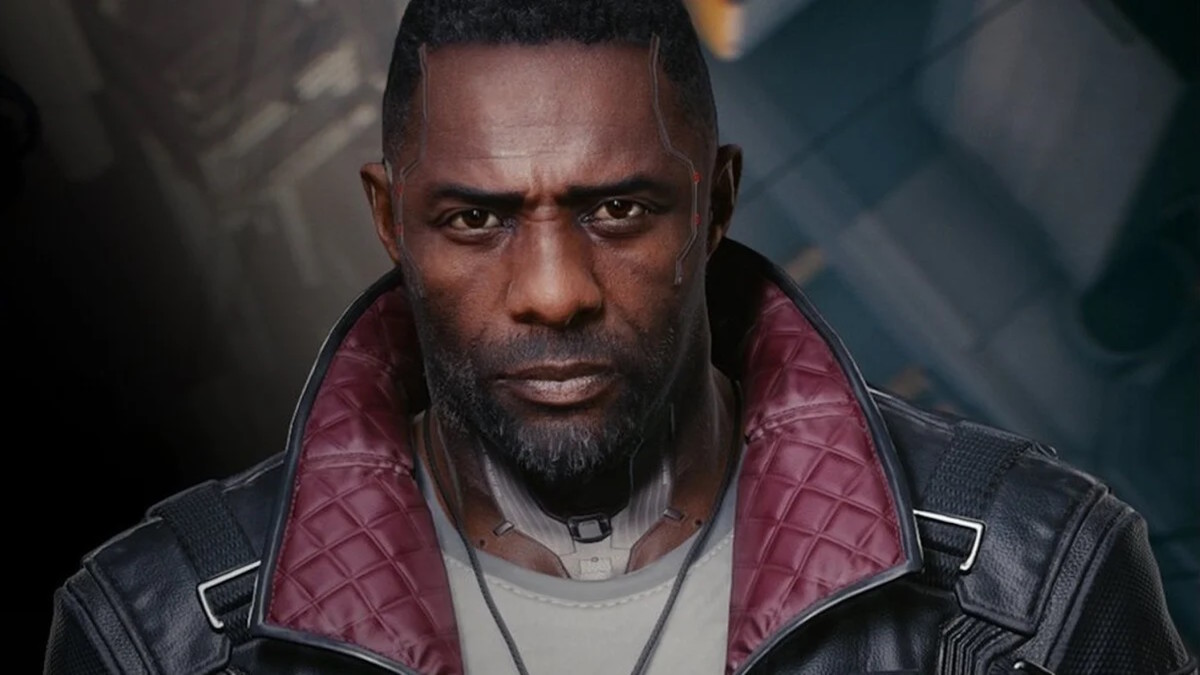 Solomon Reed, played by Idris Elba, stands in a dark room wearing a black leather jacked with red leather lining